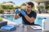 Professionnel portant des gants et des lunettes examinant un comparateur coloré au bord d’une piscine.