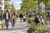 Habitants de tous âges se promenant dans un espace résidentiel contemporain arboré en plein jour.