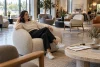 Une cliente essaie un fauteuil contemporain dans un showroom de mobilier.