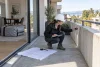 Une ingénieure inspecte la structure d’un balcon vide avant tout projet de spa.
