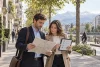 Deux adultes préparant une visite à partir d’une carte dans une ville alpine générique.
